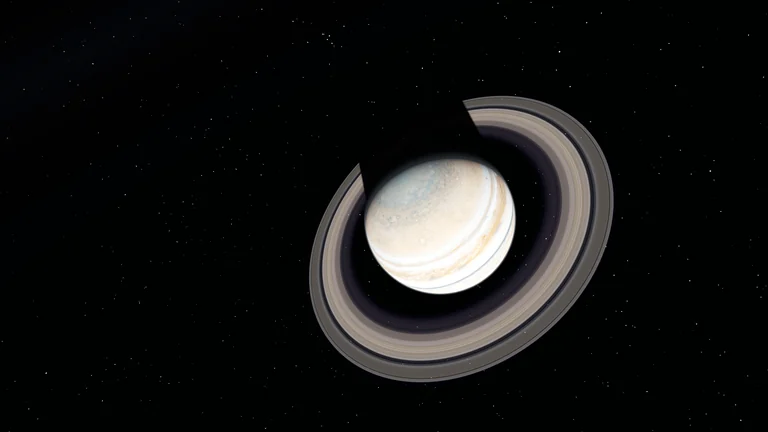 Banded gas giant with broad rings against a starfield.
