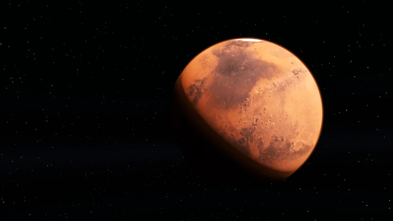 Orange rocky planet with craters along the day-night boundary.